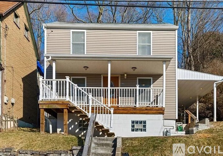 A two-story house with a deck and stairs leading to the entrance.