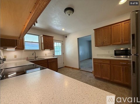 A kitchen with a granite countertop and wooden cabinets.