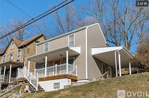 A house with a porch and a staircase leading to the entrance.