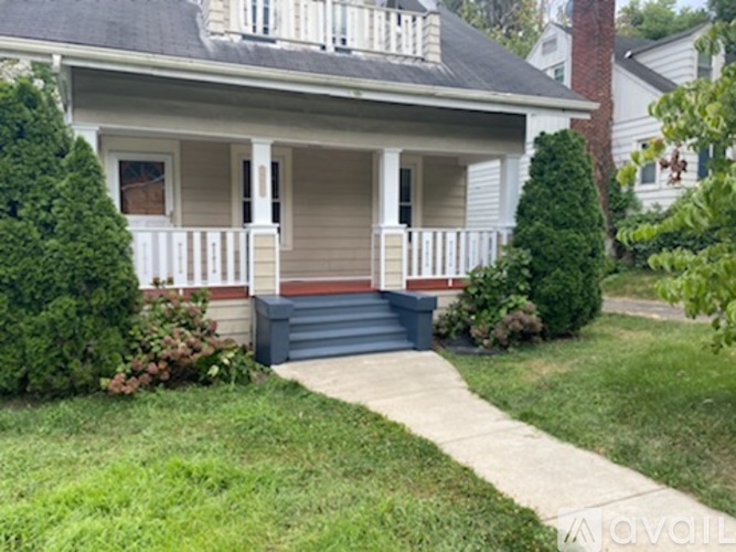 A small house with a front porch and a small front yard.