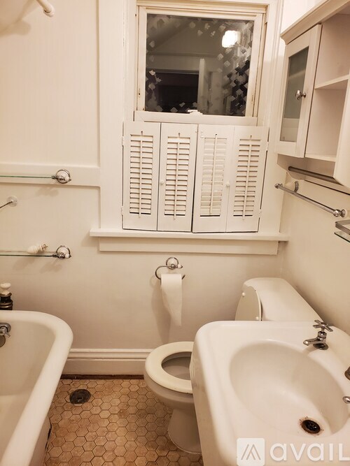 A white bathroom with a toilet, sink, and tub.