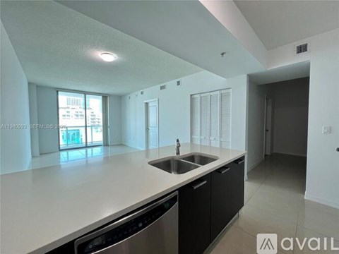 A modern kitchen with a large island and stainless steel appliances.