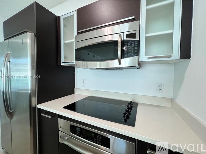A kitchen with a stainless steel refrigerator and microwave.