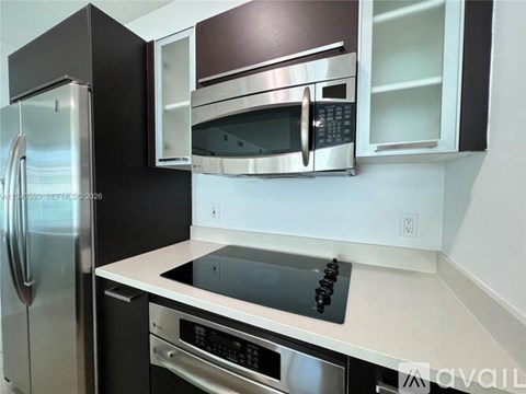 A kitchen with a stainless steel refrigerator and microwave.