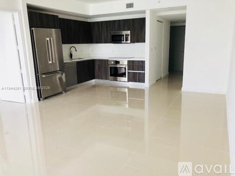 A kitchen with a refrigerator, oven, and sink.