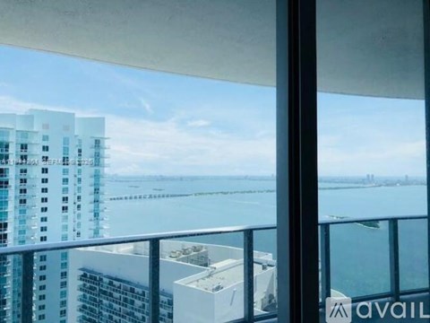 A view from a balcony overlooking a body of water with buildings in the distance.