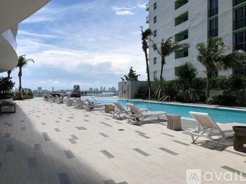 A pool area with chairs and a view of the city.