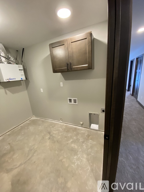 A room with a wooden cabinet and a floor that is half painted and half unpainted.