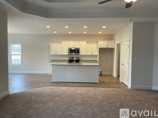 A spacious kitchen with white cabinets and a central island.