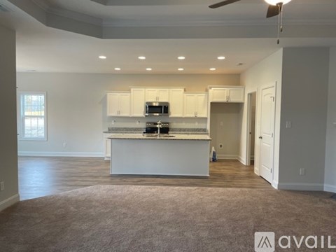 A spacious kitchen with white cabinets and a central island.
