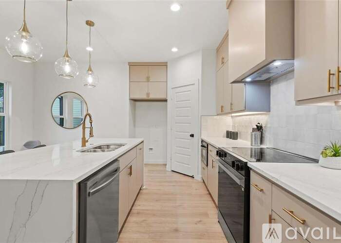 A modern kitchen with marble countertops and stainless steel appliances.