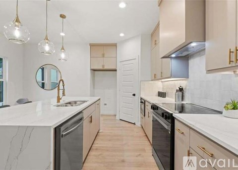 A modern kitchen with marble countertops and stainless steel appliances.