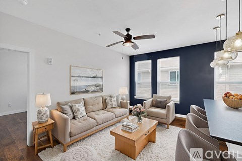 A living room with a beige sofa, a coffee table, and a painting on the wall.