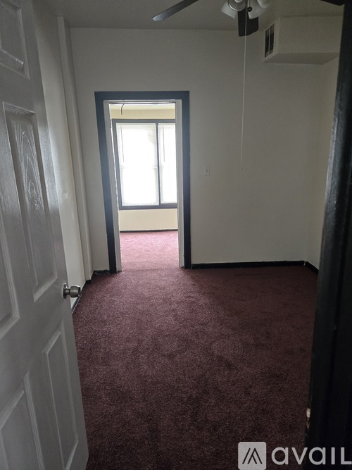 A room with a carpeted floor and a door.