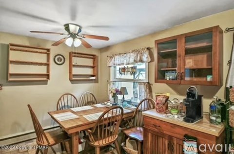 A dining room with a wooden table and chairs.