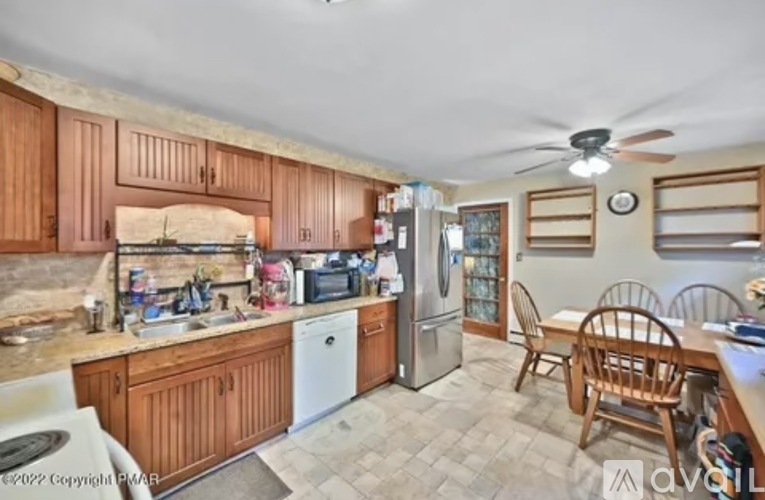A kitchen with wooden cabinets and a refrigerator.