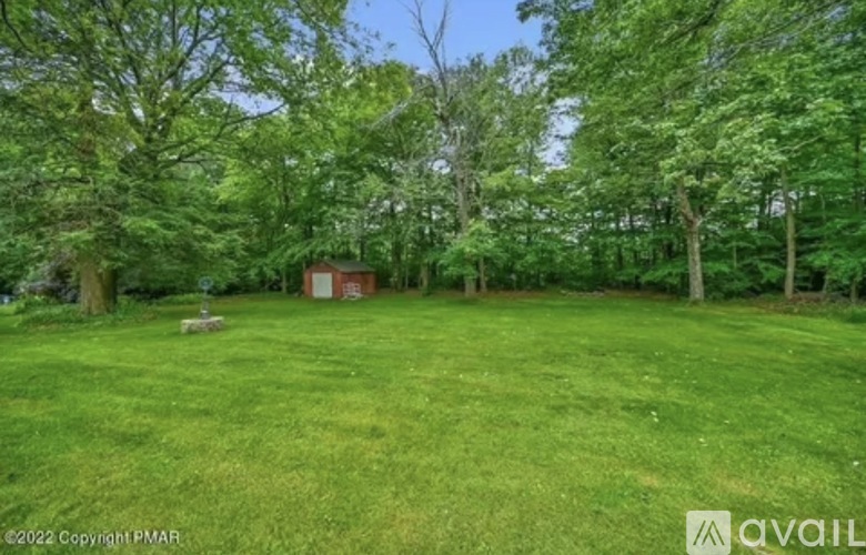 A lush green field with a small building in the distance.