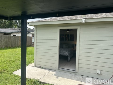 A small white shed with a bed inside.