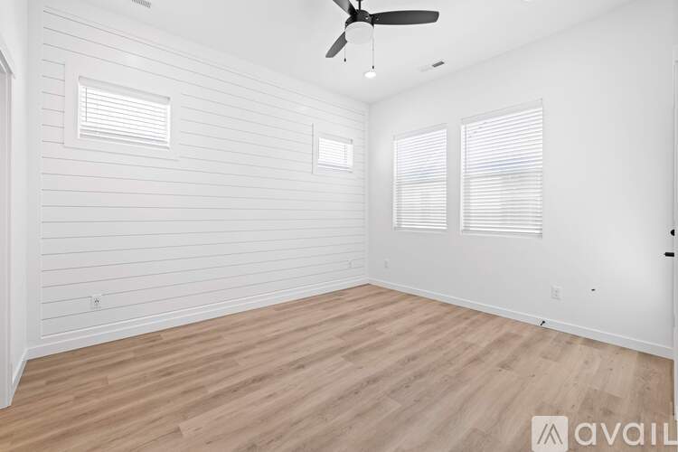 A room with wooden flooring and a ceiling fan.