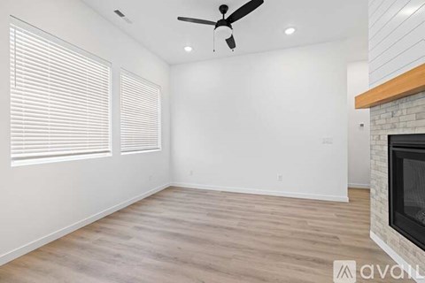 A room with a fireplace and a ceiling fan.