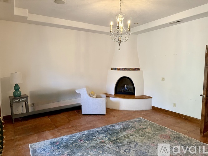 A living room with a fireplace and a chandelier.