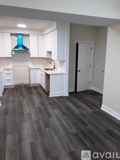 A kitchen with white cabinets and a blue hood.