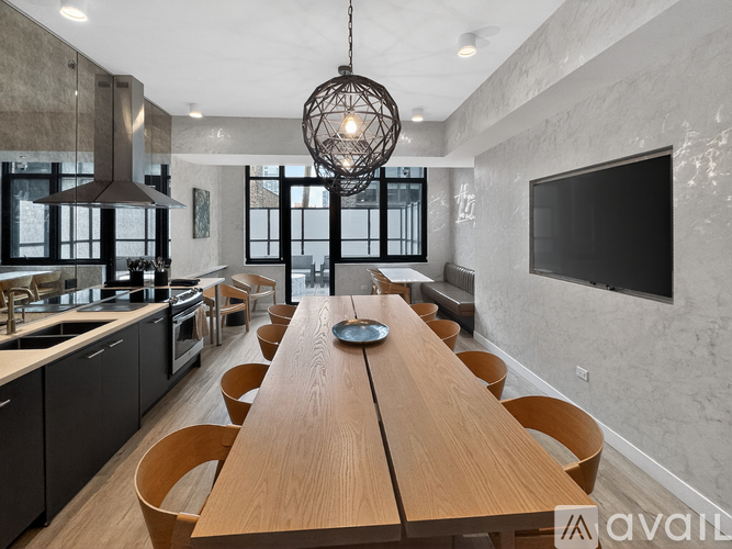 A modern kitchen with a long wooden table and chairs.