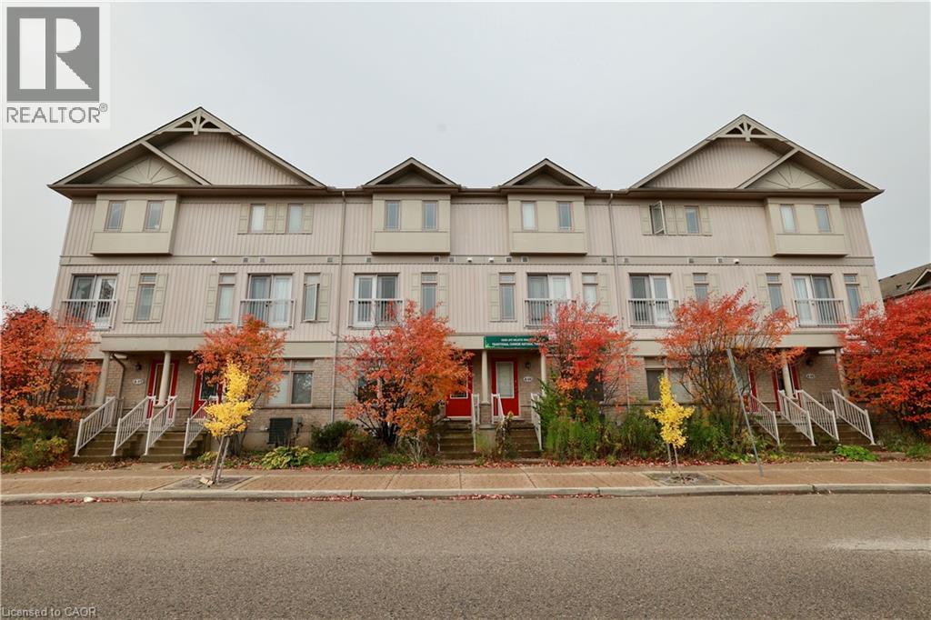 A large apartment building with a red door in the front.