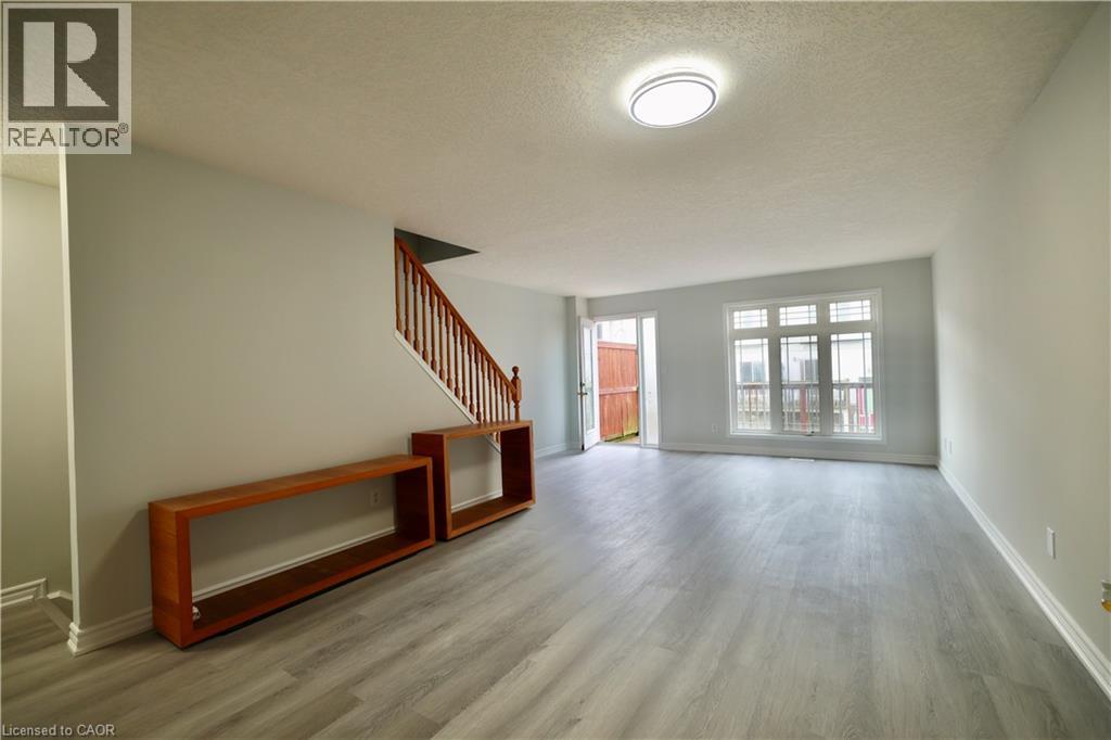A spacious room with a staircase and a window.
