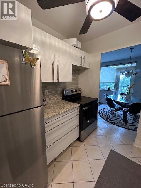 A modern kitchen with a stainless steel refrigerator and black countertops.