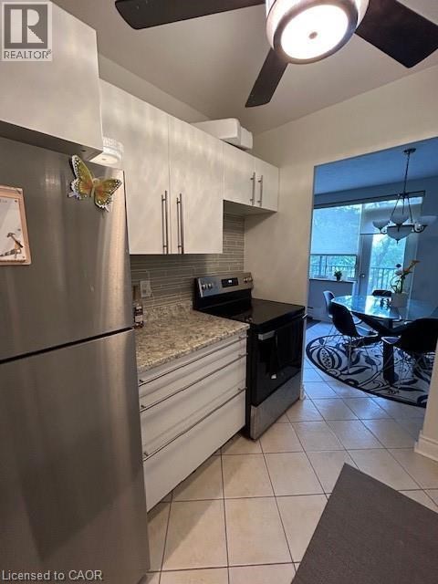 A modern kitchen with a stainless steel refrigerator and black countertops.