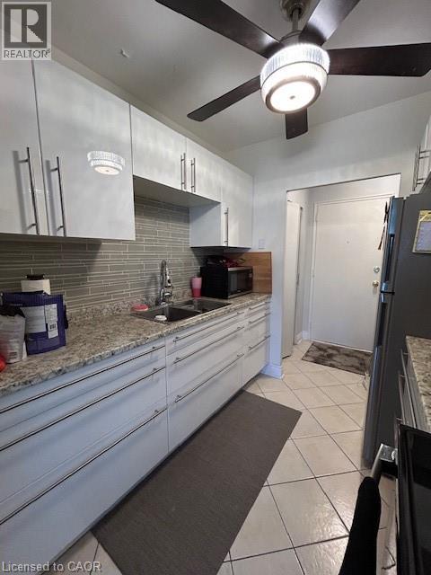A kitchen with white cabinets and a ceiling fan.