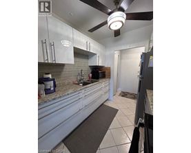 A kitchen with white cabinets and a ceiling fan.