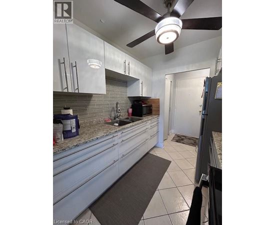 A kitchen with white cabinets and a ceiling fan.