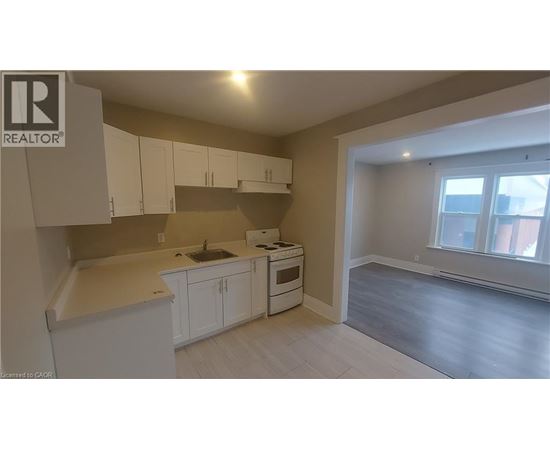 A kitchen with white cabinets and a window.