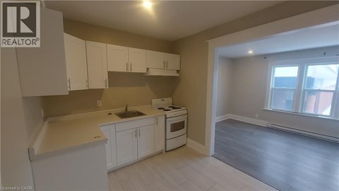 A kitchen with white cabinets and a window.