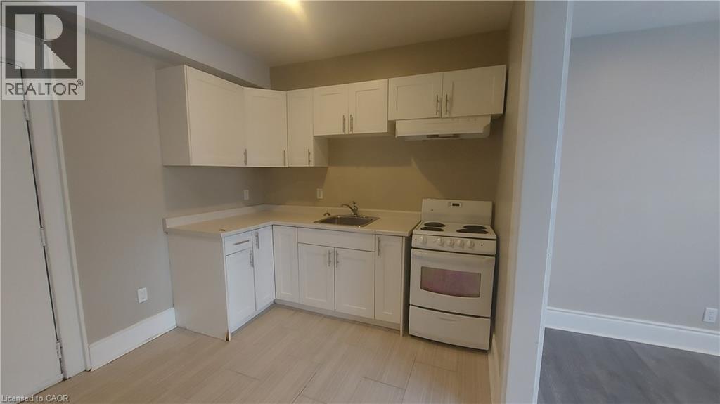 A kitchen with white cabinets and a stove top oven.
