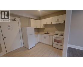 A kitchen with white cabinets and a stove top oven.