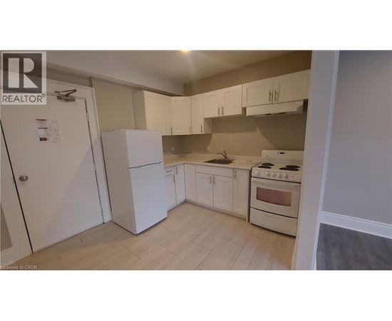 A kitchen with white cabinets and a stove top oven.