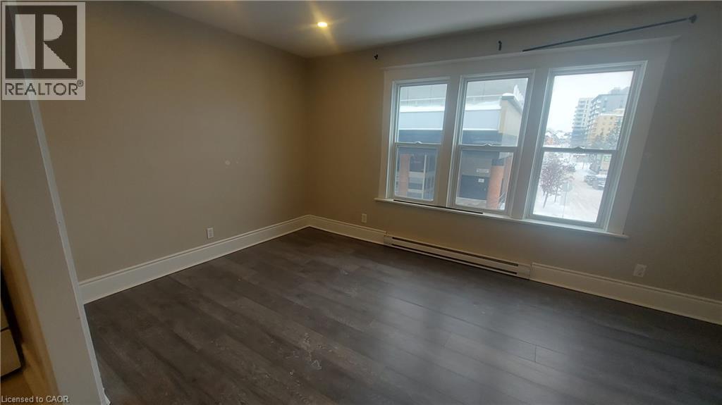 A room with a window and a wooden floor.