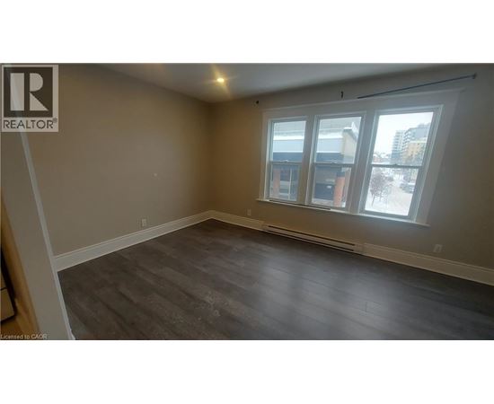 A room with a window and a wooden floor.