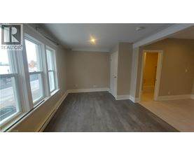A room with a window and a door is available for rent.
