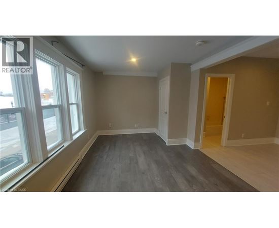 A room with a window and a door is available for rent.