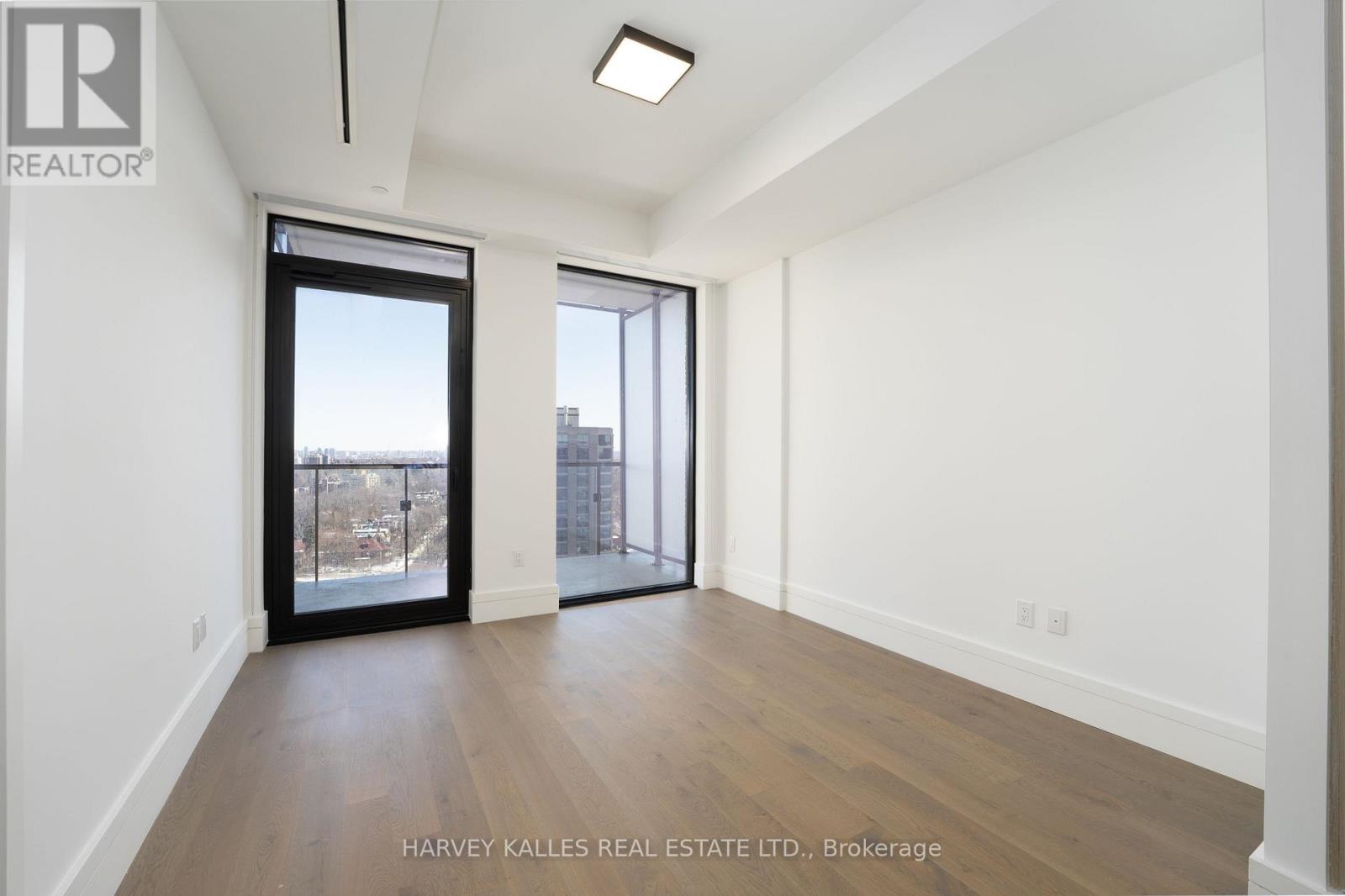A spacious room with a view of the city through a large window.