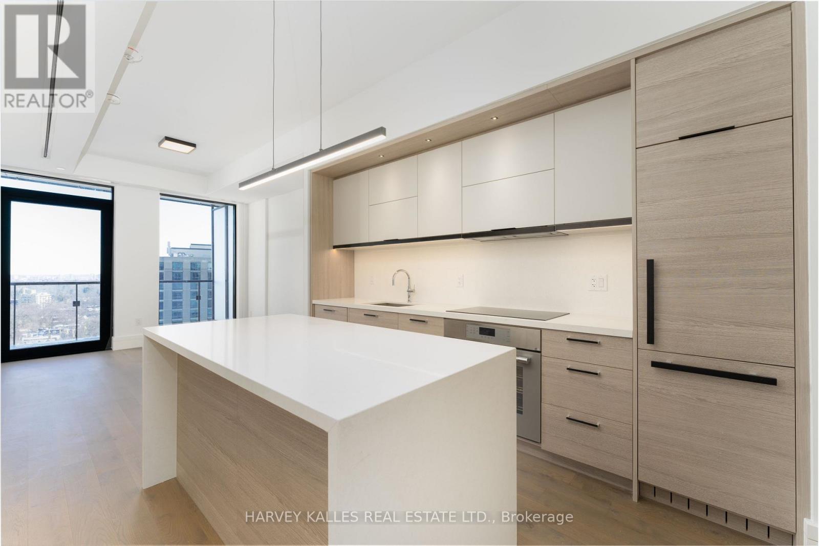 A modern kitchen with white countertops and wooden cabinets.