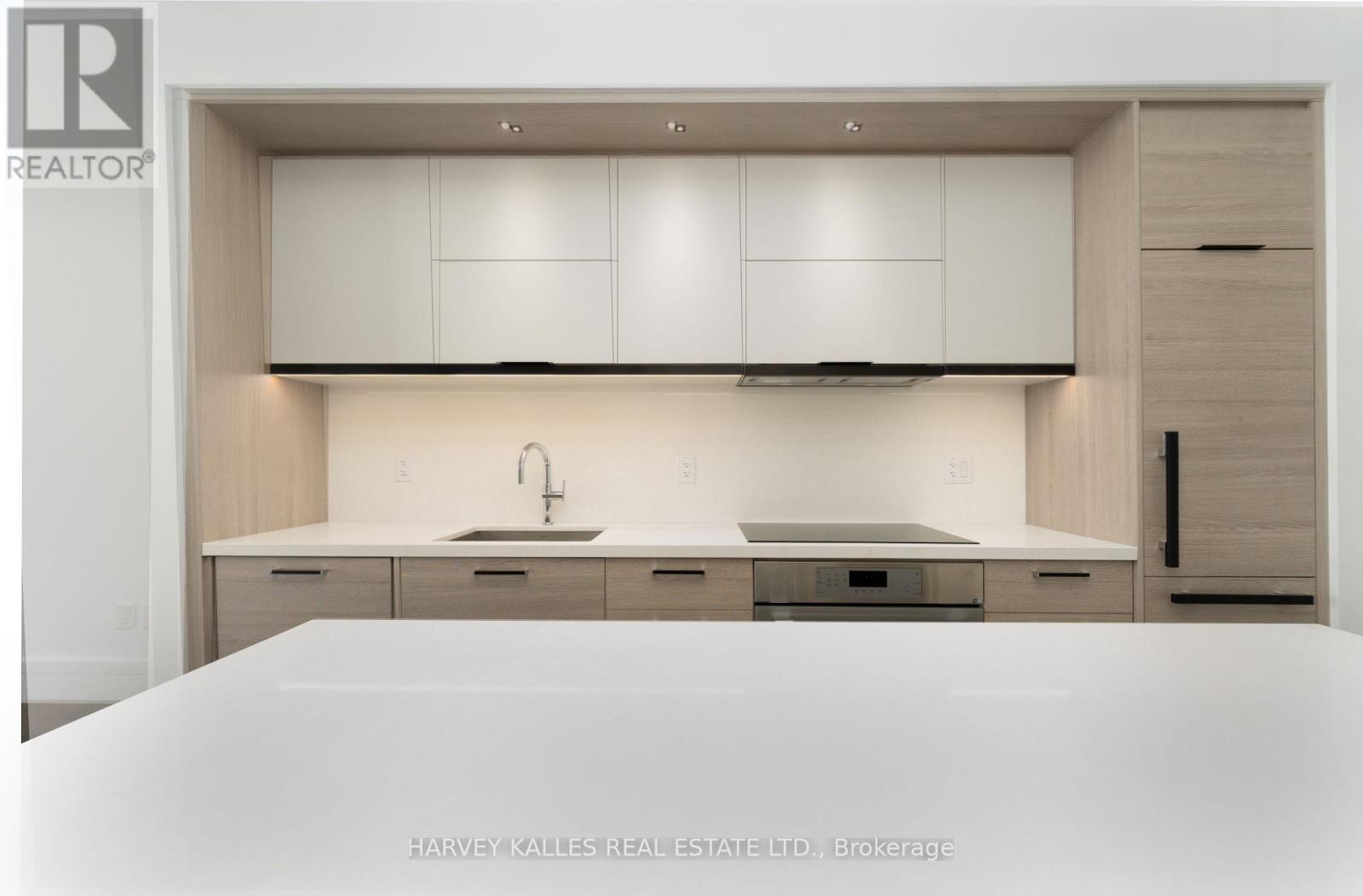A modern kitchen with white cabinets and a sink.