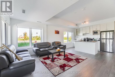 A living room with a grey couch and a red and white rug.
