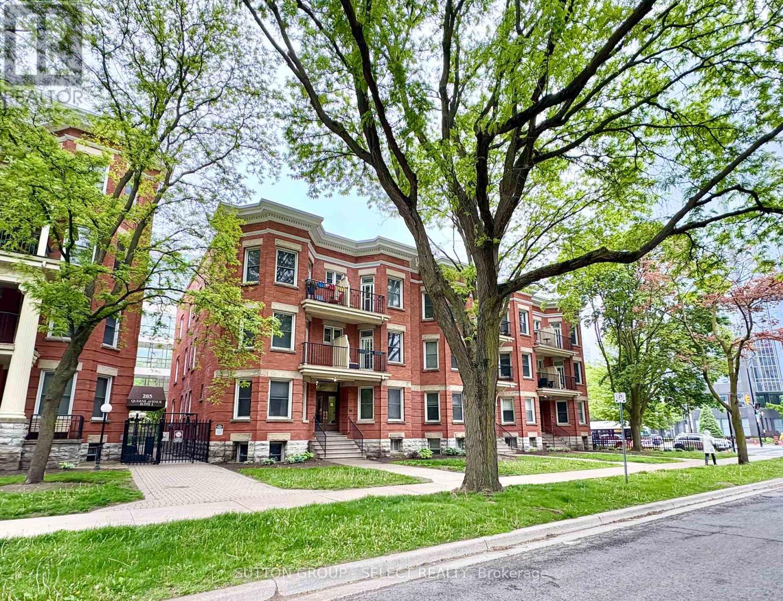 A tree in front of a red brick building.