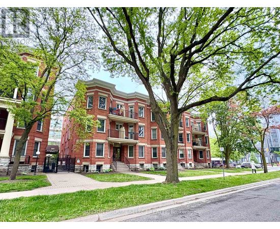 A tree in front of a red brick building.