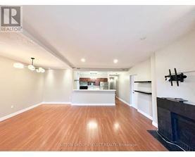 A spacious living room with wood flooring and a fireplace.
